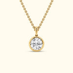Gold pendant necklace featuring a round, brilliant-cut diamond.