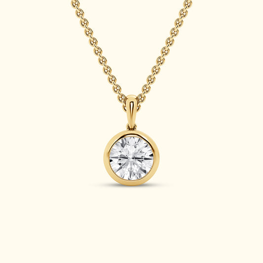 Gold pendant necklace featuring a round, brilliant-cut diamond.