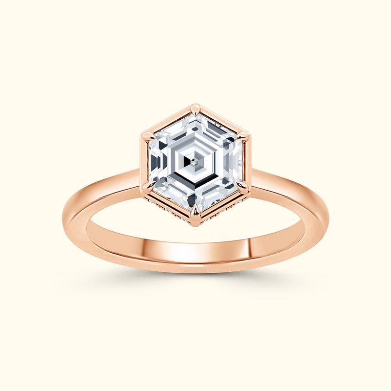 Rose gold ring featuring a hexagonal, faceted gemstone at the center.