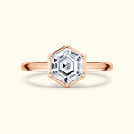 Hexagonal diamond ring with a rose gold band on a light background.