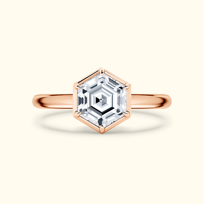 Hexagonal diamond ring with a rose gold band on a light background.