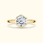 Gold hexagonal ring featuring a sparkling clear gemstone at the center.