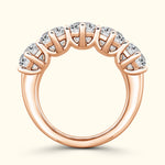 Rose gold ring featuring five sparkling stones set in a curved design.