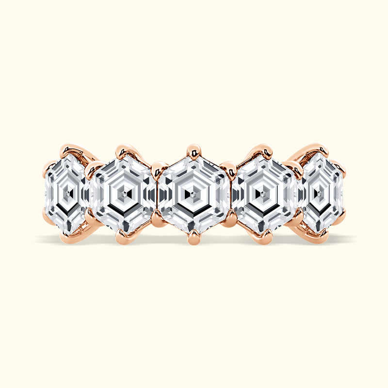 Rose gold ring featuring five hexagonal clear gemstones in a patterned design.