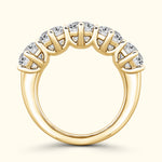 Gold band ring featuring five sparkling gemstones arranged in a row.