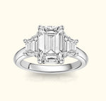 Elegant three-stone ring featuring a central emerald-cut diamond and two smaller stones.