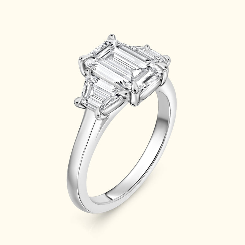 Elegant silver ring featuring a large emerald-cut center diamond flanked by smaller baguette stones.