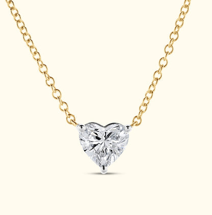Heart-shaped diamond pendant on a delicate gold chain.